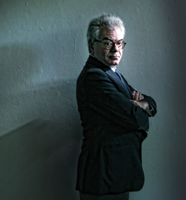 Dramatically lit photo portrait of Gary Samore with his arms crossed